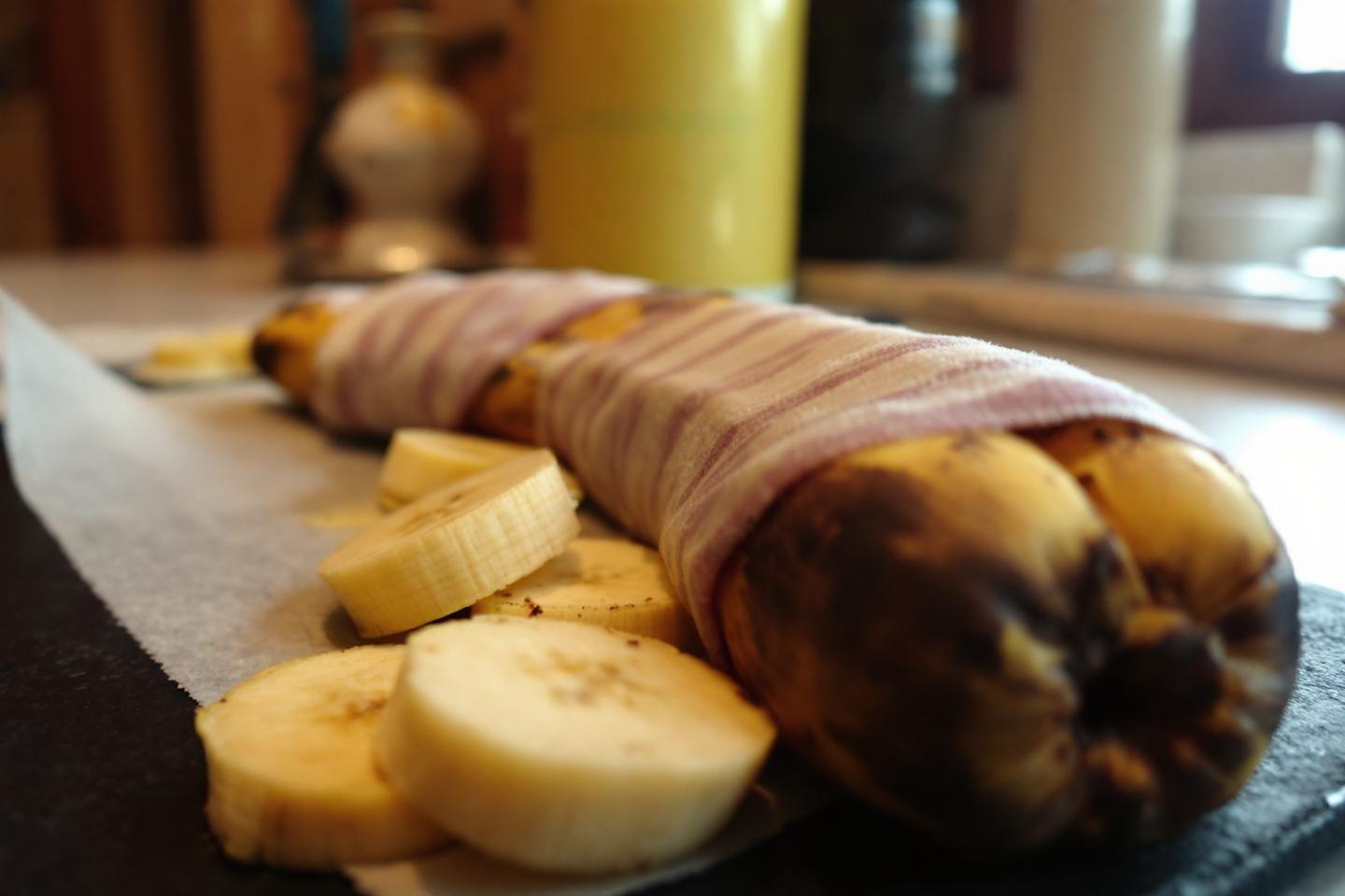 Bananes enti&egrave;res et tranch&eacute;es sur une surface sombre