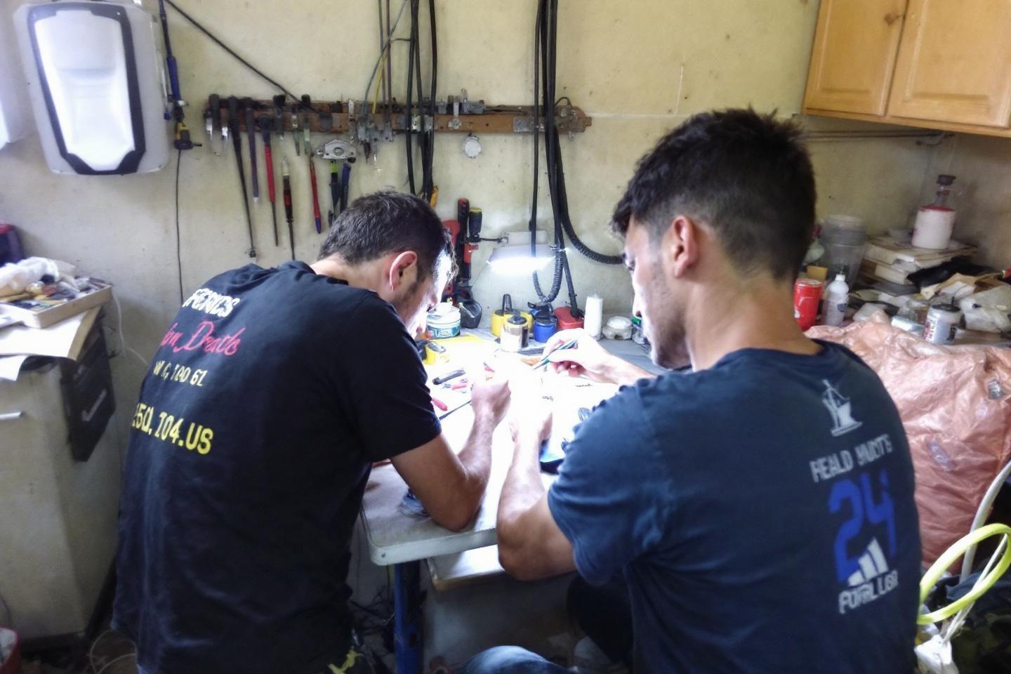 Deux hommes concentrés sur une table de travail dans un atelier