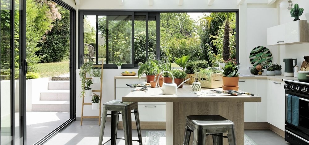 véranda aménagée en cuisine avec des plantes