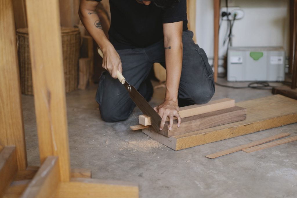 Homme en train de couper du bois dans un atelier