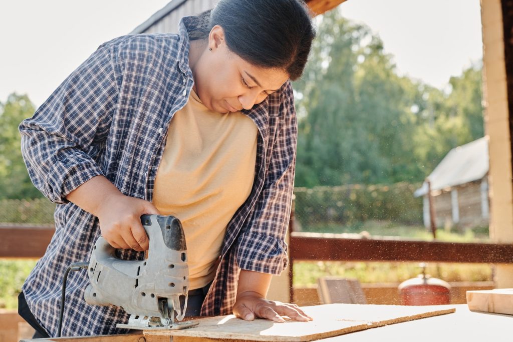 Une femme utilisant la scie sauteuse